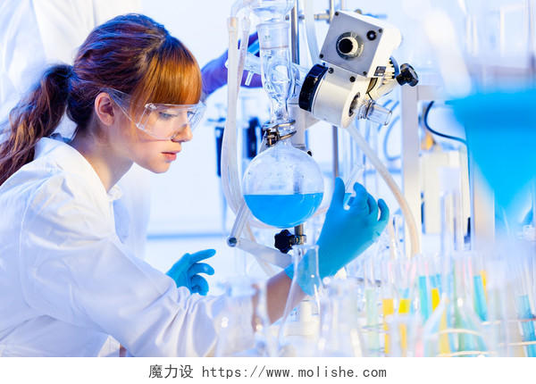 化学实验室场景吸引年轻博士学生科学家解决方案蒸馏后观察以蓝色指示器表示颜色变化